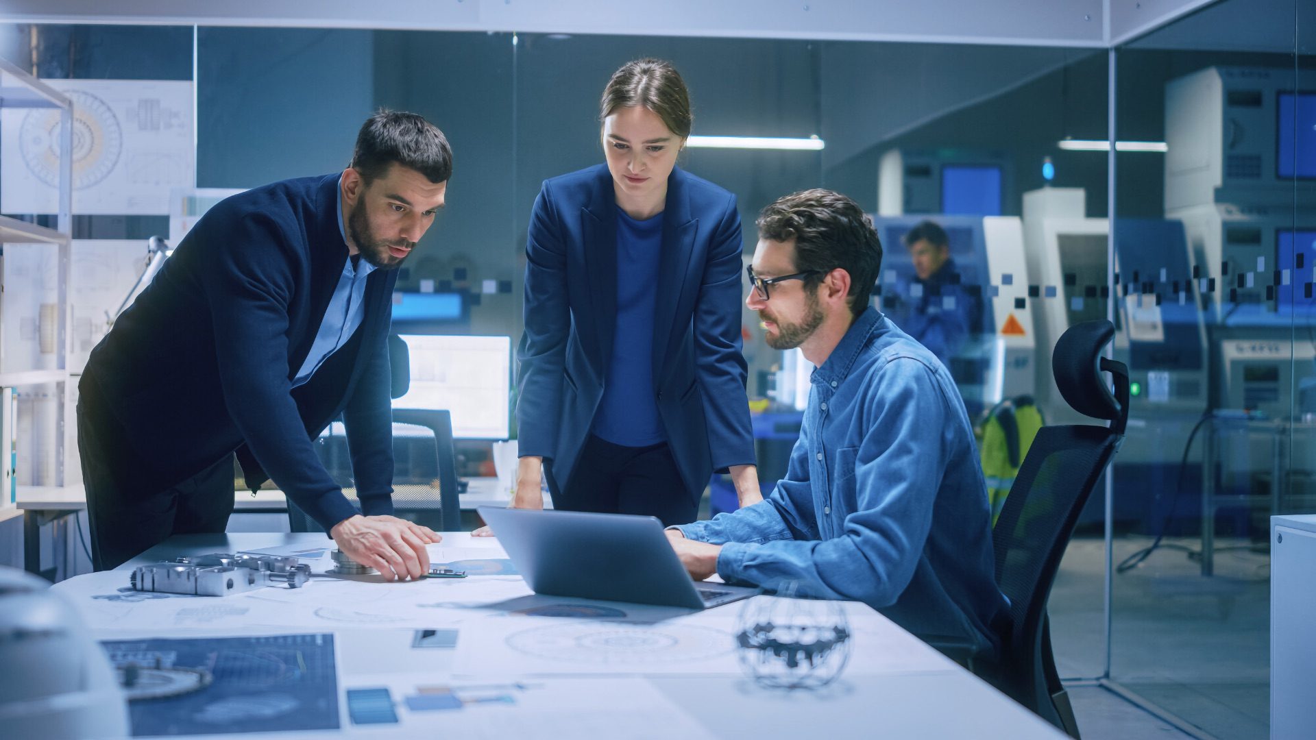 Modern Factory Office Meeting Room: Diverse Team of Engineers, Managers Talking at Conference Table, Look at Blueprints, Inspect Mechanism, Use Laptop. High-Tech Facility with CNC Machines; Shutterstock ID 1936499722; purchase_order: 1106262587; job: ; client: ; other: